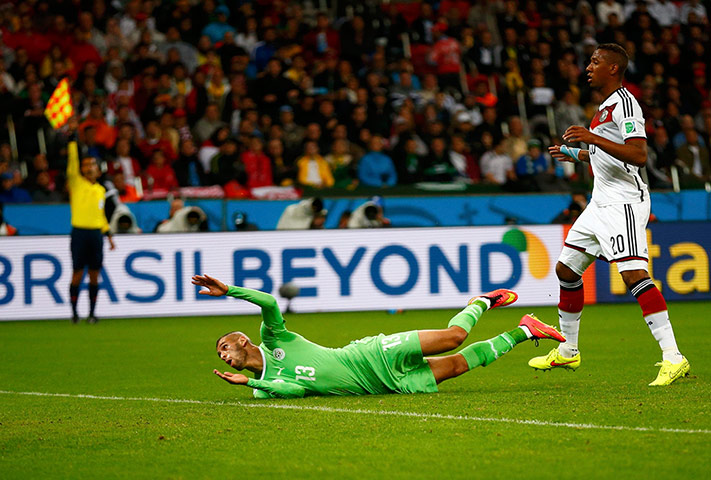 Algeria's Slimani falls on the ground after scoring a goal