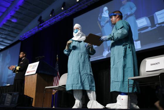 Smith and Christensen of the of the CDC's Domestic Infection Control Team for Ebola demonstrate putting on personal protective equipment during an Ebola educational session for healthcare workers in New York