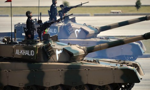 Pakistani military personnel ride Al-Khalid tanks during the Pakistan Day military parade in Islamabad on March 23, 2015. Pakistan held its first national day military parade for seven years, a display of pageantry aimed at showing the country has the upper hand in the fight against the Taliban. Mobile phone networks in the capital were disabled to thwart potential bomb attacks, some roads were closed to the public and much of the city was under heavy guard for the event. AFP PHOTO/ Aamir QURESHI