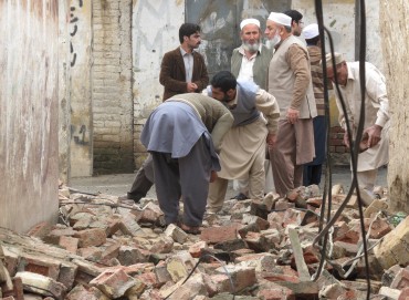 Residents gather to clear a path by removing rubble from a house after it was damaged by an earthquake in Mingora, Swat, Pakistan October 26, 2015. A powerful earthquake struck a remote area of northeastern Afghanistan on Monday, shaking the capital Kabul, as shockwaves were felt in northern India and in Pakistan's capital, where hundreds of people ran out of buildings as the ground rolled beneath them. REUTERS/Hazrat Ali Bacha