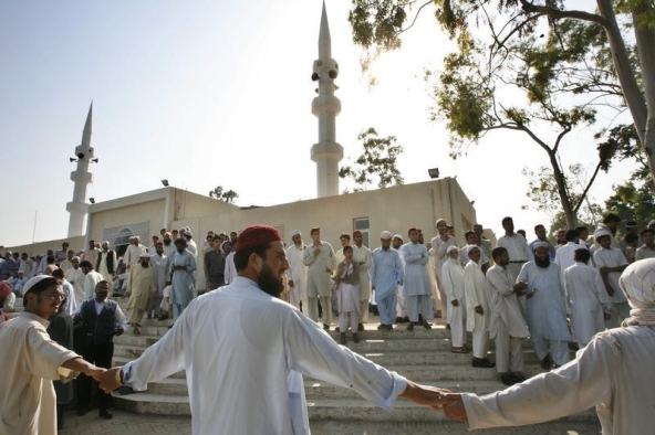 Lal Misjid or Red Mosque security personnel join hands as people leave the Mosque after prayers in Islamabad October 3, 2007. Pakistani authorities opened the mosque in the capital, Islamabad, on Wednesday nearly three months after more than 100 people were killed when commandos stormed the compound to end a siege by Islamist gunmen.   REUTERS/Mian Khursheed   (PAKISTAN) - RTR1UJI5