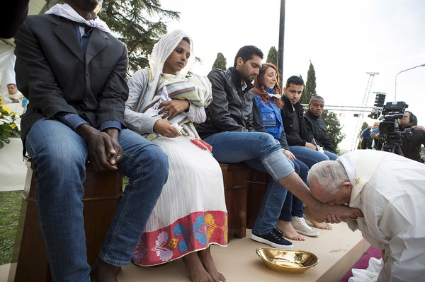 Pope Francis kisses the foot of a refugee during the foot-washing ritual at the Castelnuovo di Porto refugees center near Rome, Italy, March 24, 2016. Pope Francis on Thursday washed and kissed the feet of refugees, including three Muslim men, and condemned arms makers as partly responsible for Islamist militant attacks that killed at least 31 people in Brussels. REUTERS/Osservatore Romano/Handout via Reuters ATTENTION EDITORS - THIS PICTURE WAS PROVIDED BY A THIRD PARTY. REUTERS IS UNABLE TO INDEPENDENTLY VERIFY THE AUTHENTICITY, CONTENT, LOCATION OR DATE OF THIS IMAGE. EDITORIAL USE ONLY. NOT FOR SALE FOR MARKETING OR ADVERTISING CAMPAIGNS. NO RESALES. NO ARCHIVE. THIS PICTURE IS DISTRIBUTED EXACTLY AS RECEIVED BY REUTERS, AS A SERVICE TO CLIENTS.