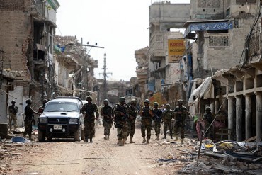 Pakistani soldiers patrol at a destroyed empty bazaar during a military operation against Taliban militants in the main town of Miranshah in North Waziristan on July 9, 2014. Last month Pakistan's military launched a long-awaited offensive in North Waziristan, aimed at wiping out longstanding militant strongholds in the area, which borders Afghanistan. More than 800,000 people have fled a major military offensive against the Taliban in a Pakistani tribal area, officials said Wednesday. AFP PHOTO/Aamir QURESHI