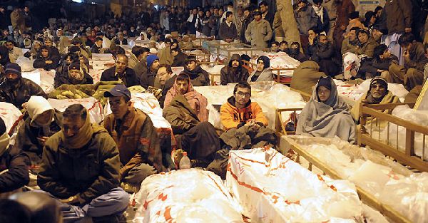 Pakistani Shiite Muslims demonstrate and sit between the coffins of bomb blast victims in Quetta on January 12, 2013. Shiite families refusing to bury their dead after twin bombings in Pakistan's troubled southwestern city of Quetta vowed to continue their sit-in protest until the army takes over security. Sunni militant group Lashkar-e-Jhangvi claimed responsibility for the bombings, which took place in an area dominated by Shiite Muslims from the Hazara ethnic minority and killed 92 people, with 121 wounded. AFP PHOTO / Banaras KHAN